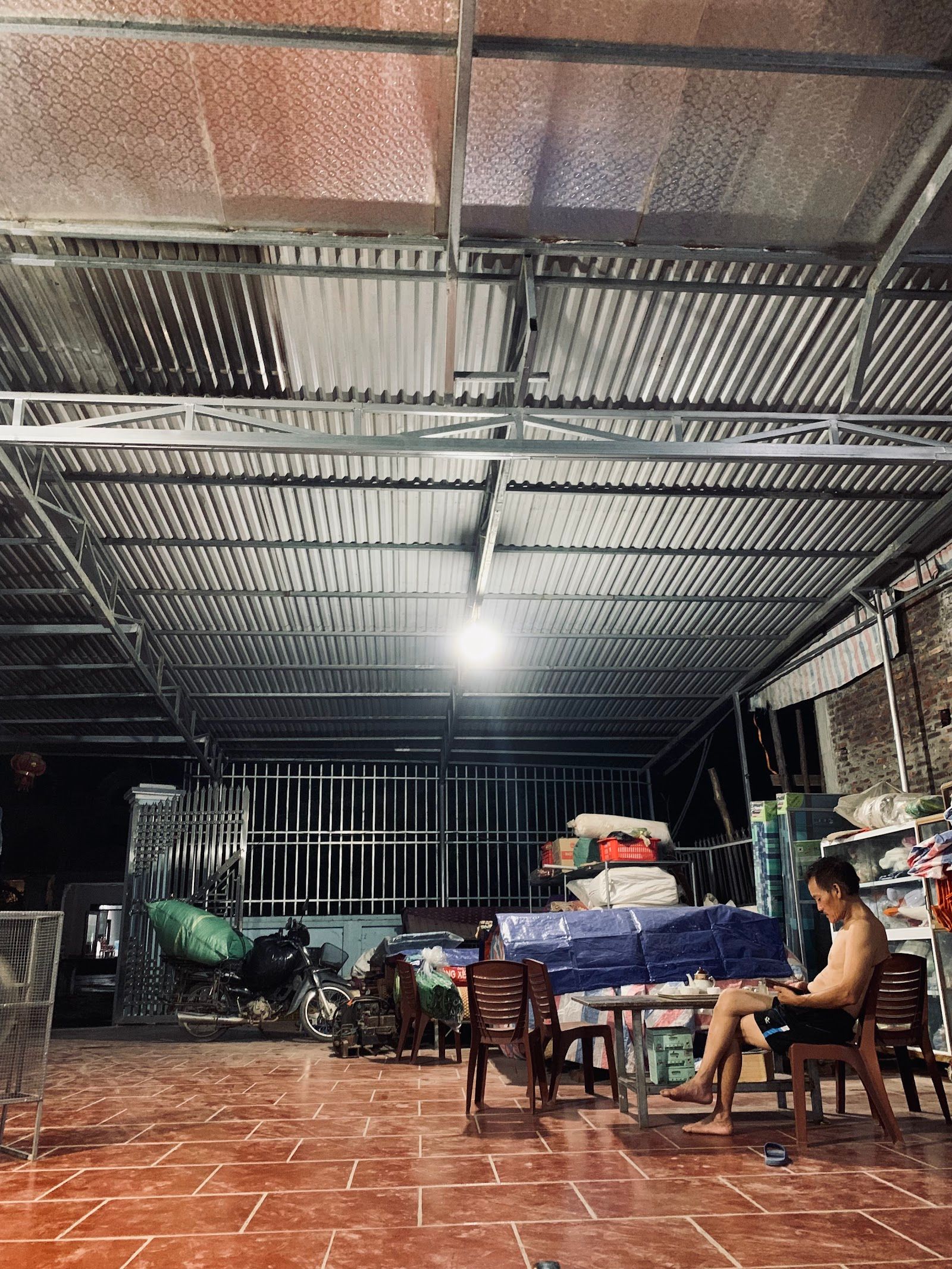 Gian bán hàng cơ sở 1: mái tôn rộng, sàn lát gạch, kệ hàng bên phải.